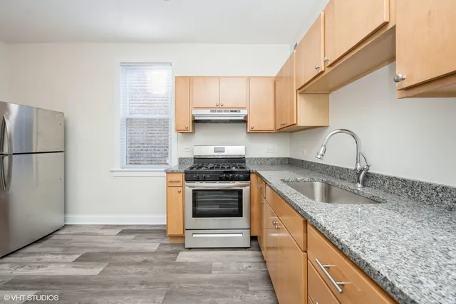 a kitchen with granite countertop a sink stove and refrigerator