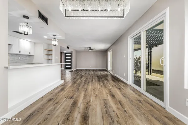 a view of a living room and kitchen with wooden floor