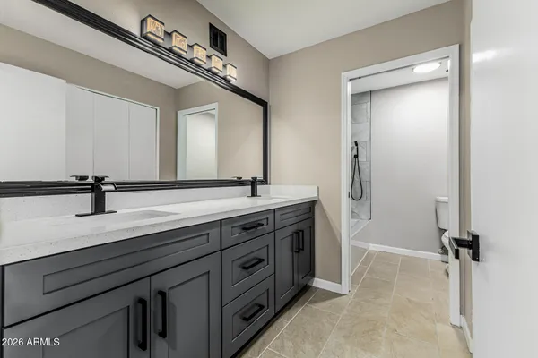 a bathroom with a double vanity sink a mirror and a bathtub