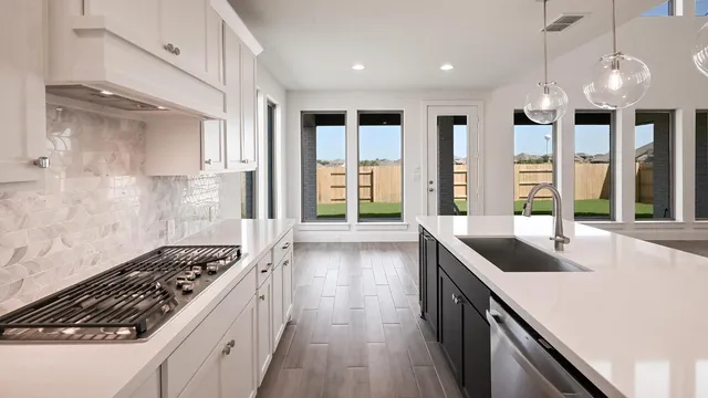 a kitchen with kitchen island granite countertop a sink and a stove