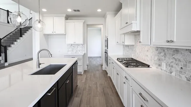 a kitchen with kitchen island a sink appliances and cabinets