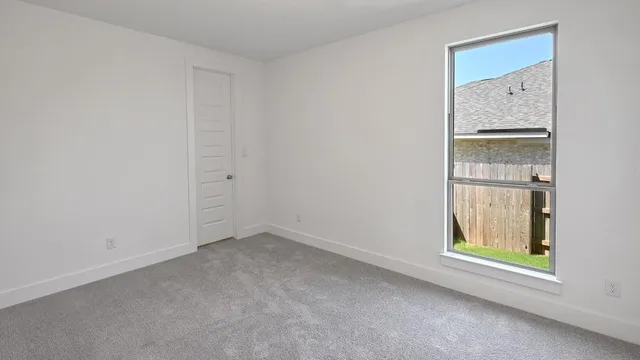 an empty room with a window and mirror