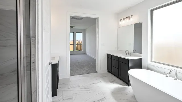 a spacious bathroom with a double vanity sink a mirror and a bathtub