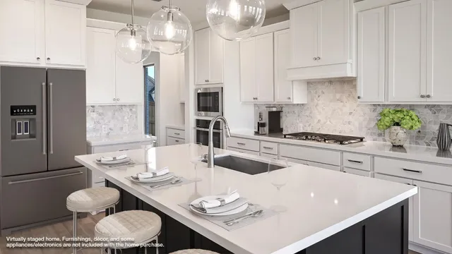 a kitchen with stainless steel appliances kitchen island granite countertop a white table and chairs