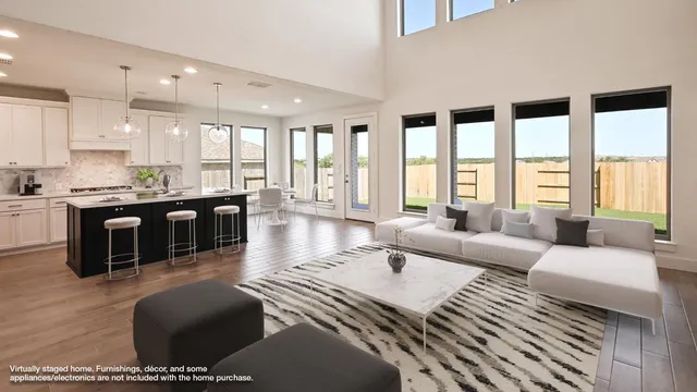 a living room with furniture large windows and wooden floor