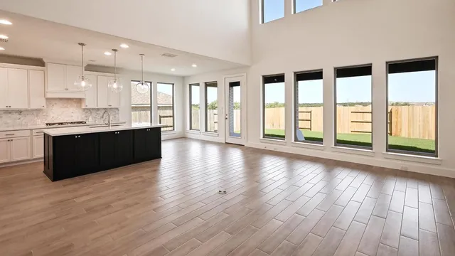 a large kitchen with stainless steel appliances granite countertop a large cabinets a sink and wooden floor