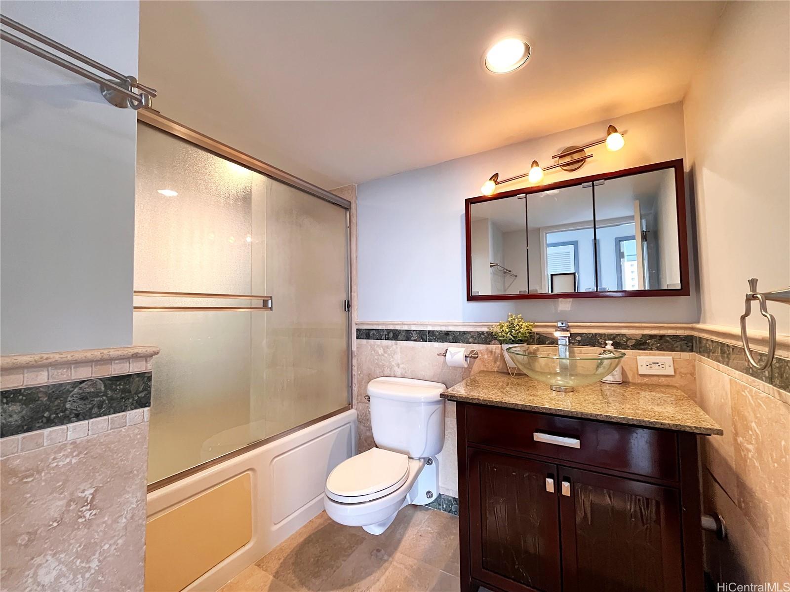 419 Atkinson Drive, Unit 1205 Honolulu, HI 96814 - Photo 9 of 15 a bathroom with a sink vanity mirror and toilet