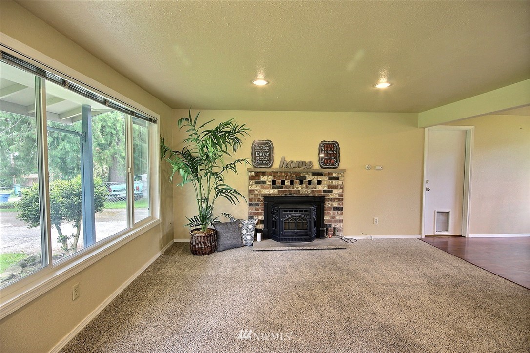 7308 Vandermark Road East Bonney Lake, WA 98391 - Photo 2 of 30 a view of an empty room with a fireplace and a floor to ceiling window