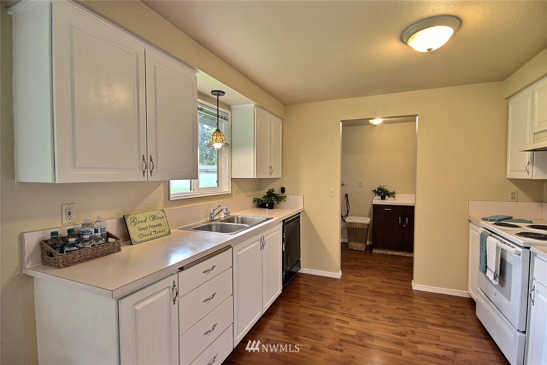 7308 Vandermark Road East Bonney Lake, WA 98391 - Photo 6 of 30 a kitchen that has a sink and a stove in it
