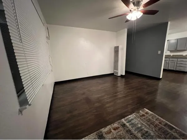 a view of an empty room with wooden floor
