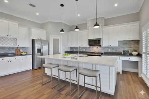 an empty room with wooden floor cabinet and windows