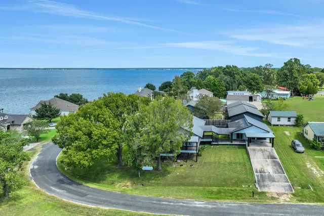 an aerial view of a house with a yard and lake view