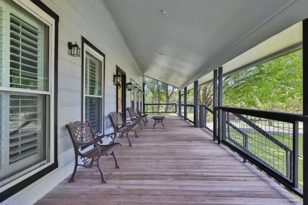 a view of trees and deck with wooden floor and outdoor seating