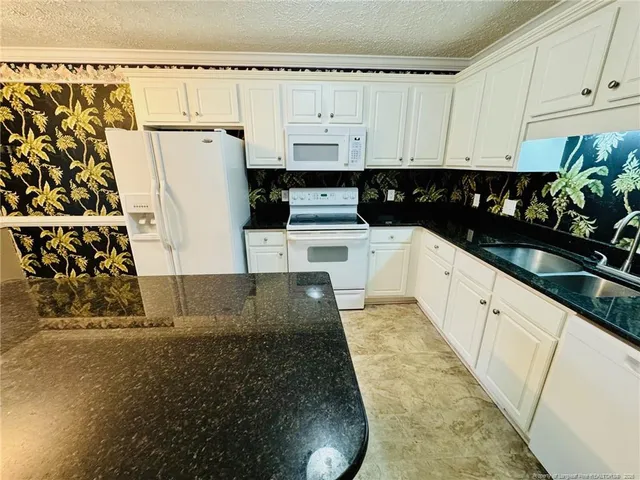a kitchen with white cabinets and white appliances
