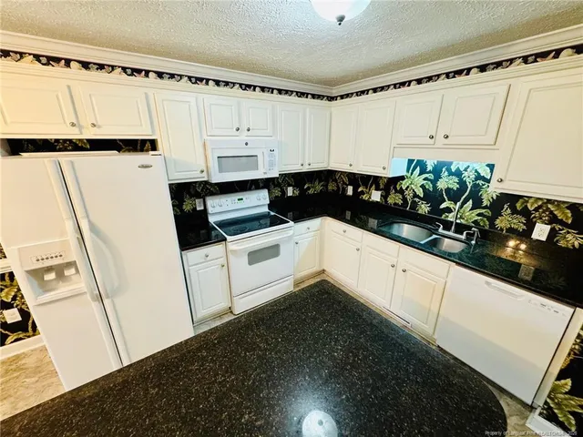 a kitchen with sink a refrigerator and cabinets