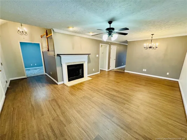 wooden floor fireplace and windows in an empty room