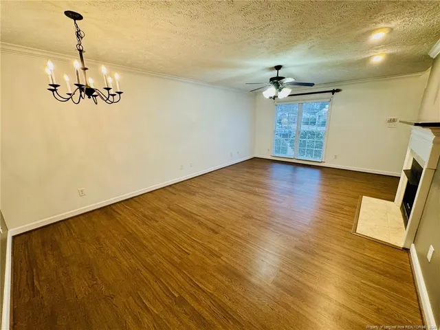 a view of a room with a wooden floor and a ceiling fan