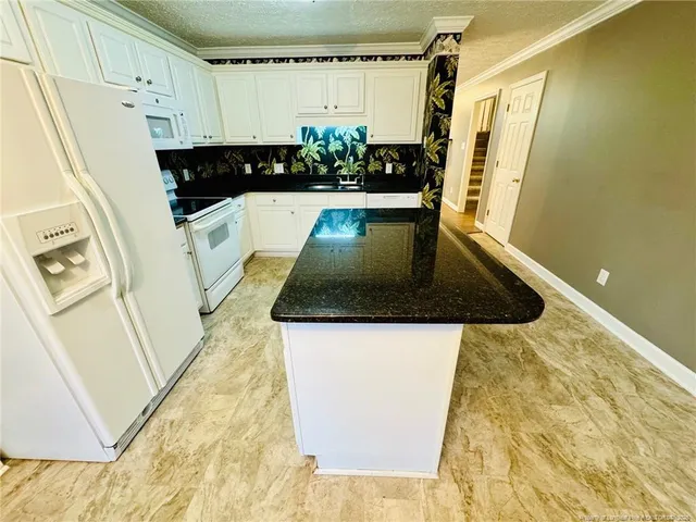 a kitchen with sink a refrigerator and a stove