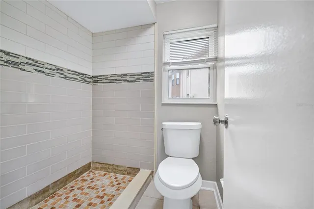 a bathroom with a toilet and a shower