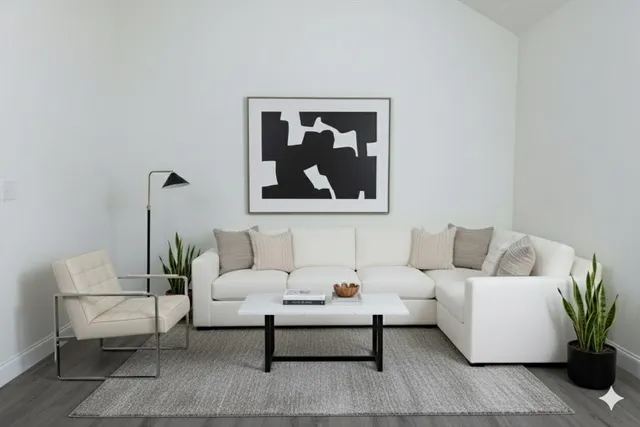 a living room with furniture and a painting on the wall