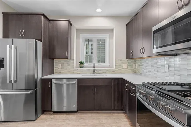 a kitchen with stainless steel appliances a sink stove and refrigerator