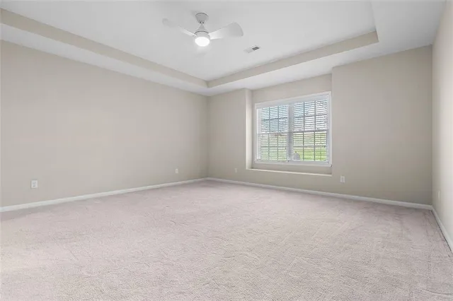 an empty room with a window and a ceiling fan