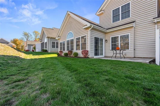 a front view of a house with a yard and trees