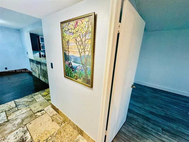 a view of walk in closet with wooden floor and bedroom view