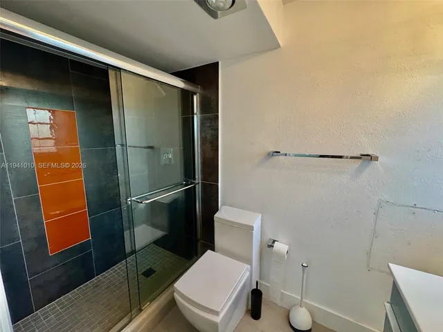 a bathroom with a toilet and a shower