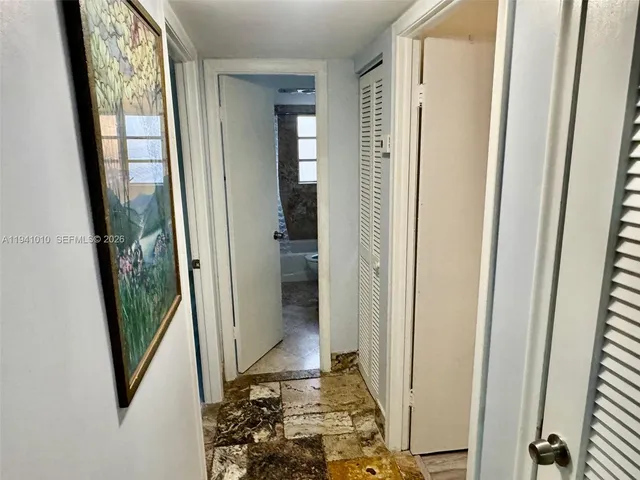 a view of a hallway with wooden floor and stairs