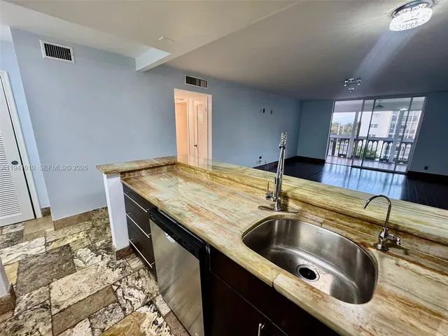 a kitchen with a sink a counter space and dining table