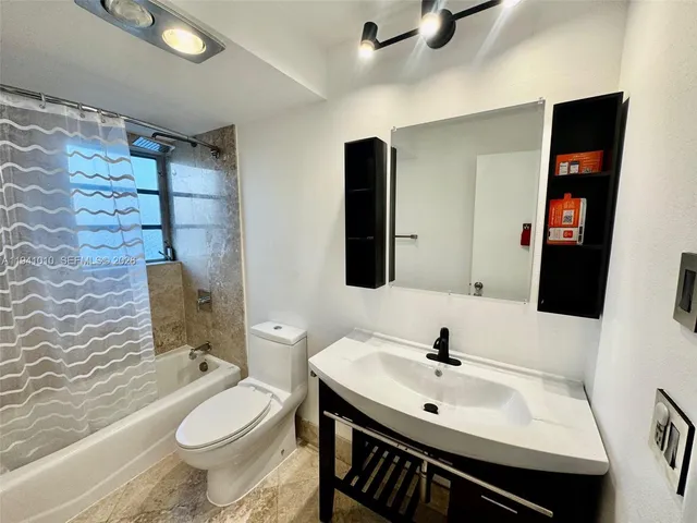 a bathroom with a sink toilet and shower