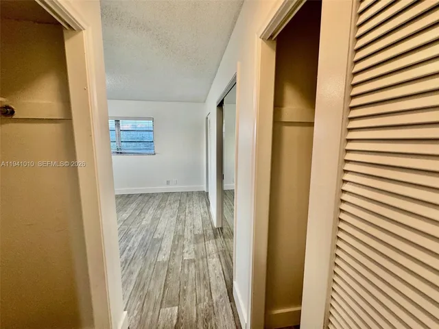 a view of a room with wooden floor and windows