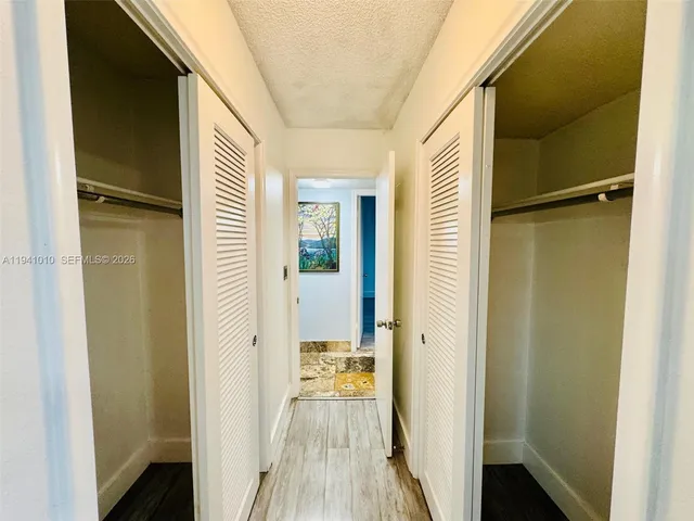 a view of a hallway with wooden floor