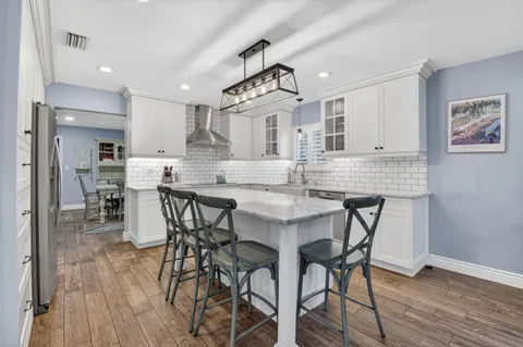 a kitchen with granite countertop white cabinets and white appliances