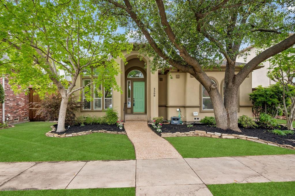 View of front of house with stucco siding and a front yard