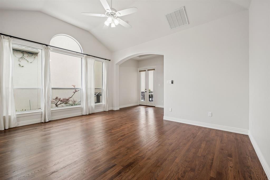3309 Ricci Lane Irving, TX 75062 - Photo 16 of 36 Bedroom with arched walkways, vaulted ceiling, a ceiling fan, hardwood floors, and french doors to the side deck