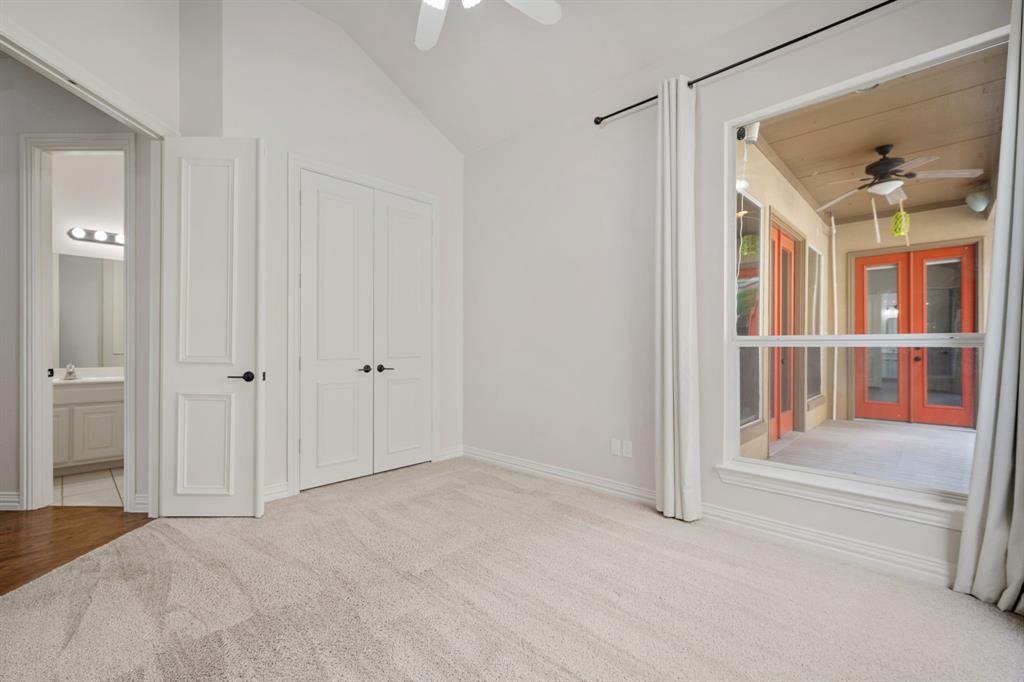 3309 Ricci Lane Irving, TX 75062 - Photo 22 of 36 Unfurnished bedroom with light carpet, french doors, vaulted ceiling, ceiling fan, and ensuite bathroom