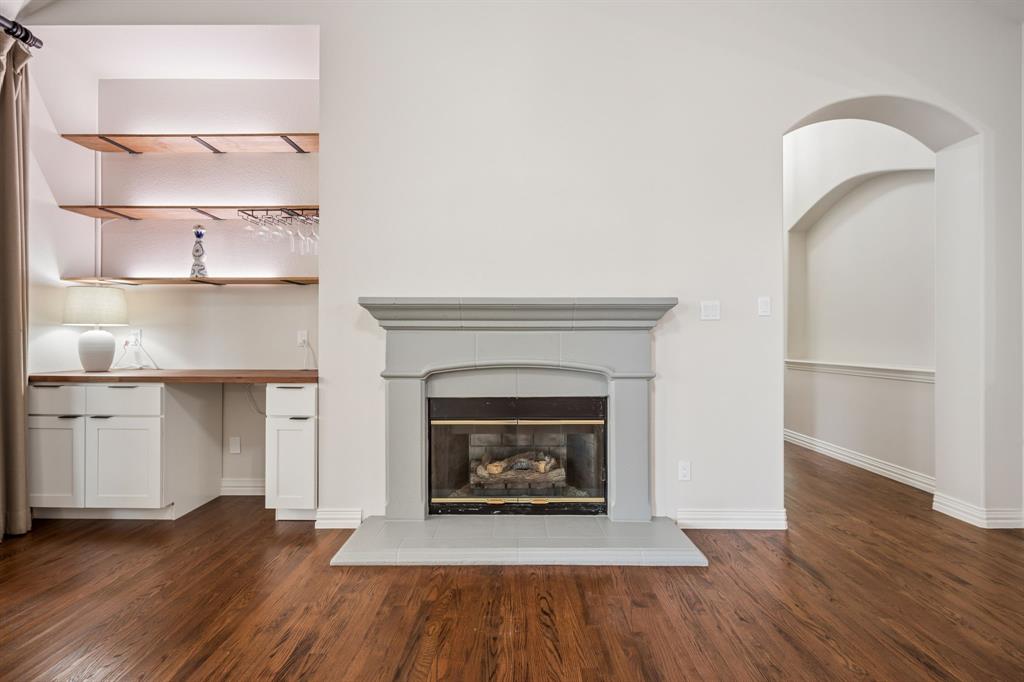 3309 Ricci Lane Irving, TX 75062 - Photo 9 of 36 Unfurnished living room featuring hardwood floors and a tile fireplace
