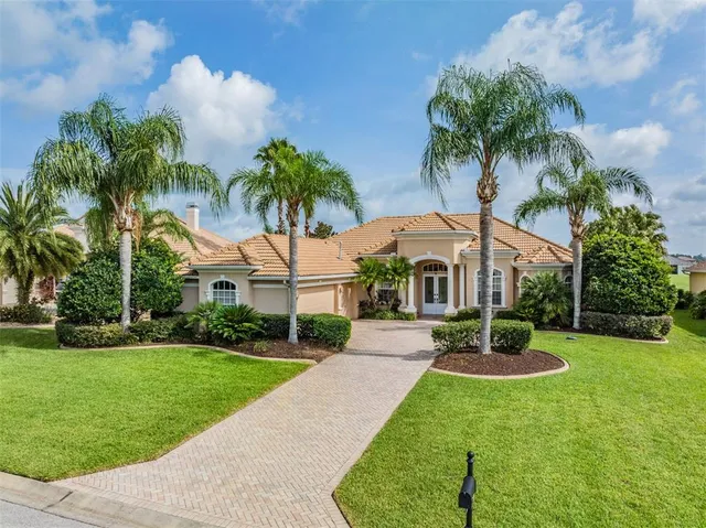 a front view of a house with garden and trees