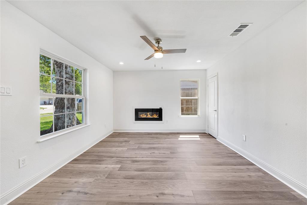1608 Wynn Terrace Arlington, TX 76010 - Photo 3 of 28 a view of an empty room with a window and wooden floor
