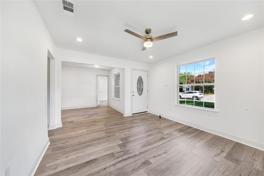 1608 Wynn Terrace Arlington, TX 76010 - Photo 4 of 28 an empty room with wooden floor ceiling fan and windows