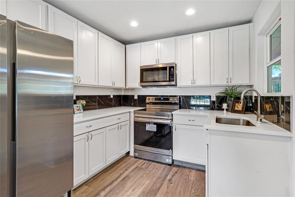 1608 Wynn Terrace Arlington, TX 76010 - Photo 7 of 28 a kitchen with white cabinets sink and stainless steel appliances