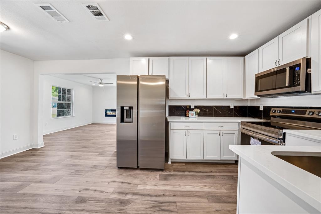 1608 Wynn Terrace Arlington, TX 76010 - Photo 10 of 28 a kitchen with granite countertop a refrigerator and a stove top oven