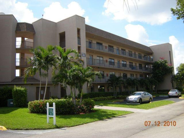 2981 North Nob Hill Road, Unit 406 Sunrise, FL 33322 - Photo 1 of 24 a view of a building with a yard and a garden