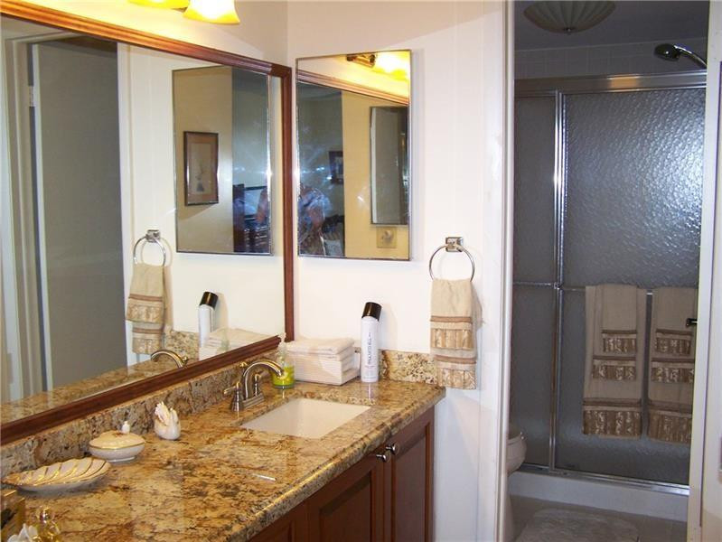 2981 North Nob Hill Road, Unit 406 Sunrise, FL 33322 - Photo 16 of 24 a bathroom with a granite countertop sink and a mirror