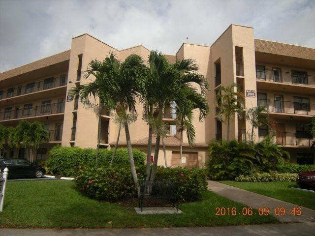 2981 North Nob Hill Road, Unit 406 Sunrise, FL 33322 - Photo 2 of 24 a front view of multi story residential apartment building with yard and green space