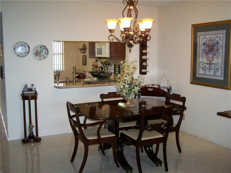 2981 North Nob Hill Road, Unit 406 Sunrise, FL 33322 - Photo 7 of 24 a dining room with furniture and chandelier