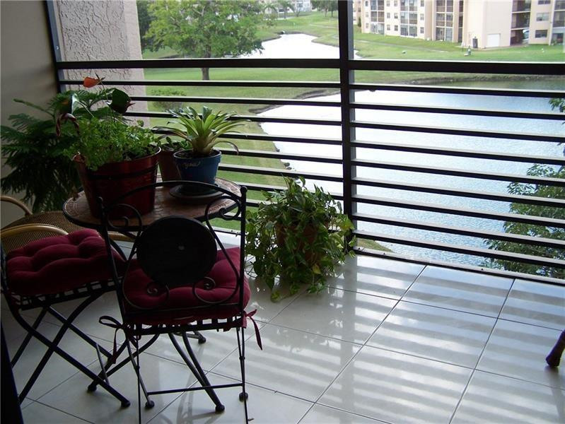 2981 North Nob Hill Road, Unit 406 Sunrise, FL 33322 - Photo 10 of 24 a backyard of a house with table and chairs and potted plants