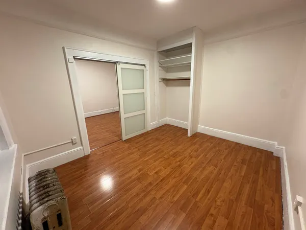 a view of empty room with wooden floor
